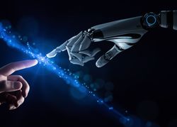 A digital conceptual photo showing a human hand extending into the middle of the image from the bottom left, while a robotic hand extends to the middle from the upper right hand corner. Both hands have their index fingers extended and are about to touch. There is a blue line of energy in the negative space between their fingers cutting diagonally across the image from the top left to the bottom right. 