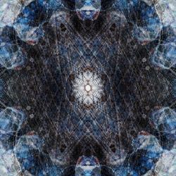 A kaleidoscopic pattern made up of a light outer ring of overlapping shades giving way to a bluer ring and then a central circle with a white circular pattern in the middle. 