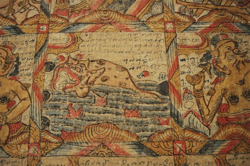 Close-up of a Balinese astrological calendar, which shows a grid filled with artwork, including a rendition of a fish.