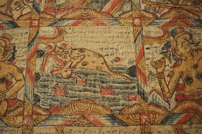 Close-up of a Balinese astrological calendar, which shows a grid filled with artwork, including a rendition of a fish.