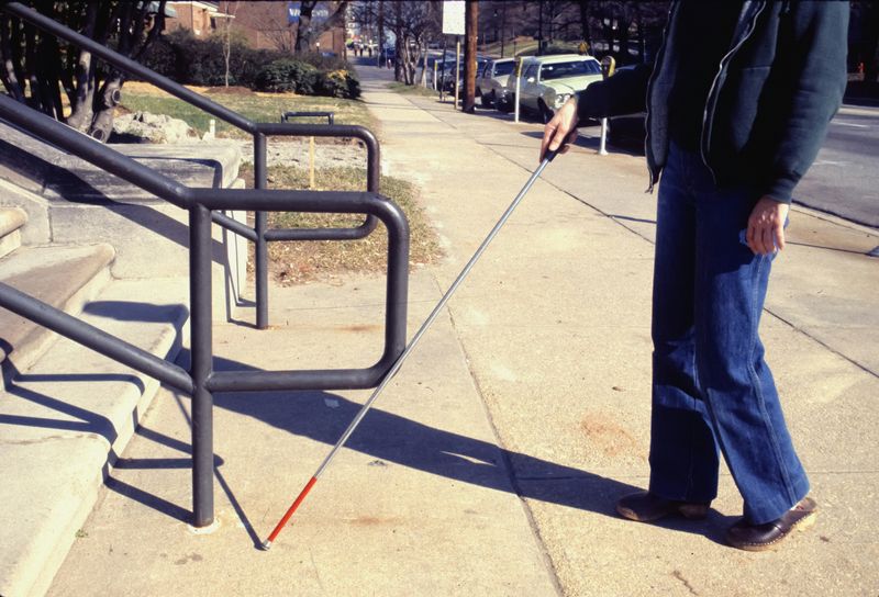 A blind person using a stick to walk.