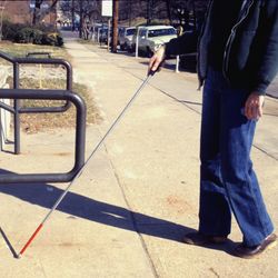 A blind person using a stick to walk.