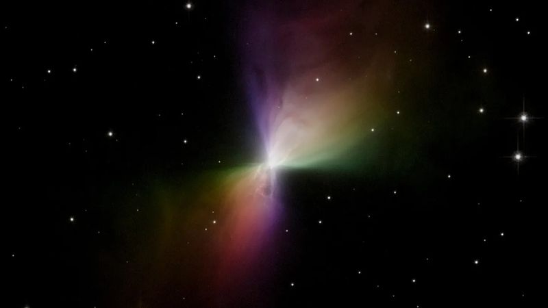 Hubble Space Telescope image of the Boomerang Nebula; the nebula is rainbow-colored and bow-shaped, surrounded by a black background dotted with stars