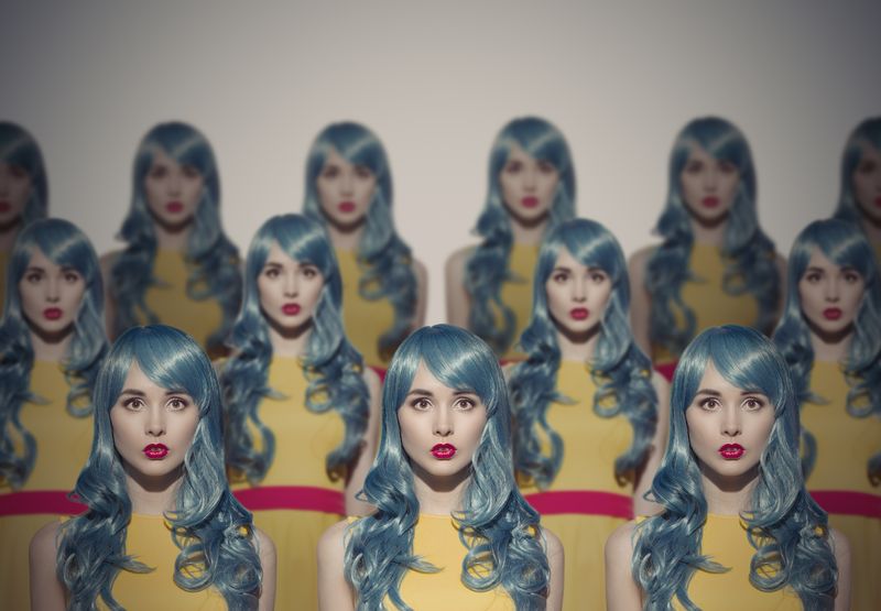 a group of human clones standing together in a crowd
