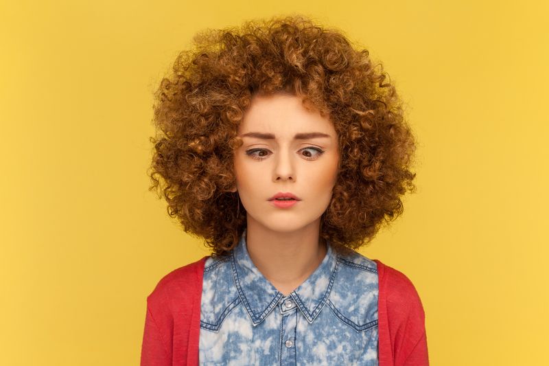 A woman looking cross-eyed as she tries to look at her own nose. 