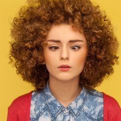 A woman looking cross-eyed as she tries to look at her own nose. 