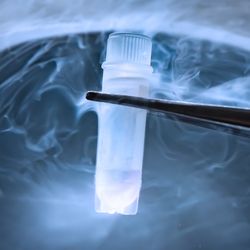 small test tube held in tweezers over a container of dry ice
