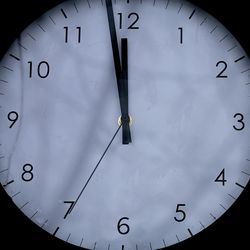 A clock in the dark showing 85 seconds to midnight.