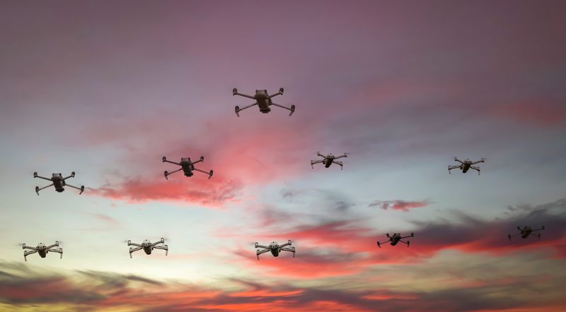 ten drones are seen flying in formation in the dusky sky