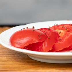 fruit flies on a plate of sliced tomato