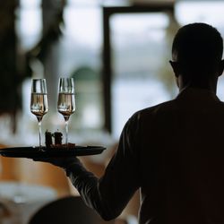 A professional waiter serves sparkling drinks at a modern restaurant, creating an elegant dining experience.