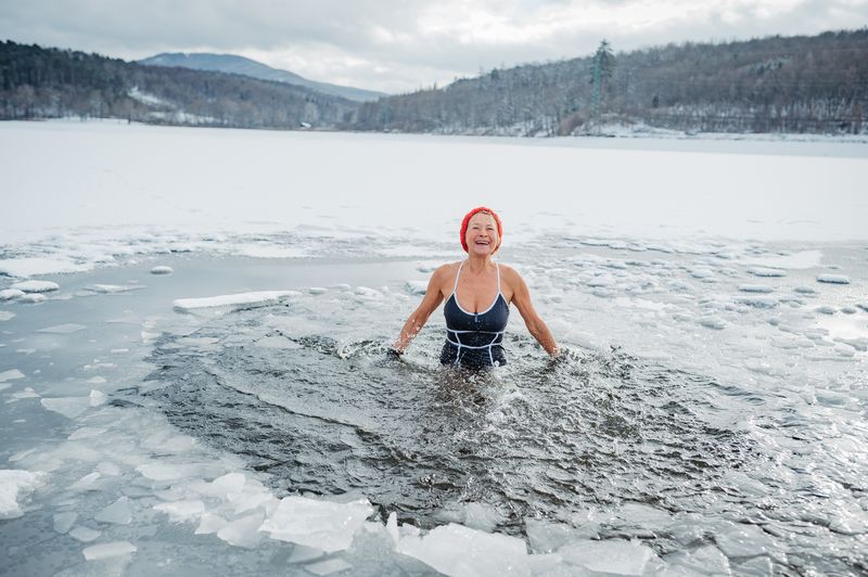 A woman in Finland swimming in ice lake.