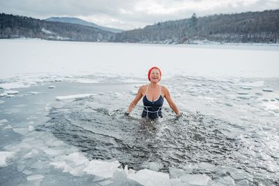 A woman in Finland swimming in ice lake.
