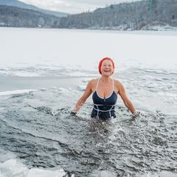A woman in Finland swimming in ice lake.
