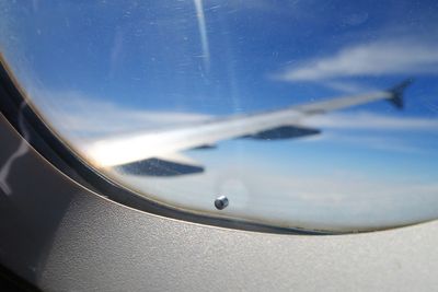 A tiny "breather hole" or "bleed hole" on the window of an airplane.