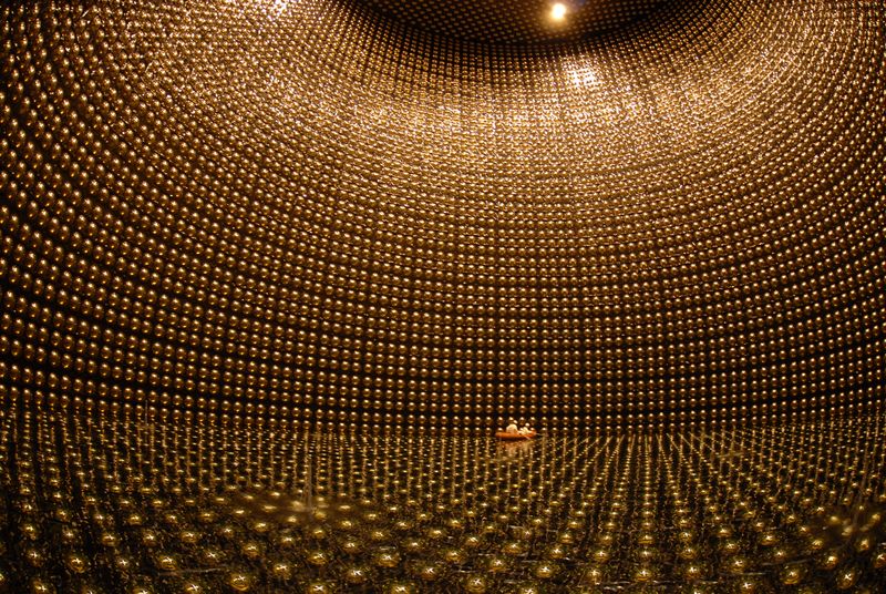 The vast interior of the super kamiokande detector, whose walls are lined with gold photomultiplier tubes.