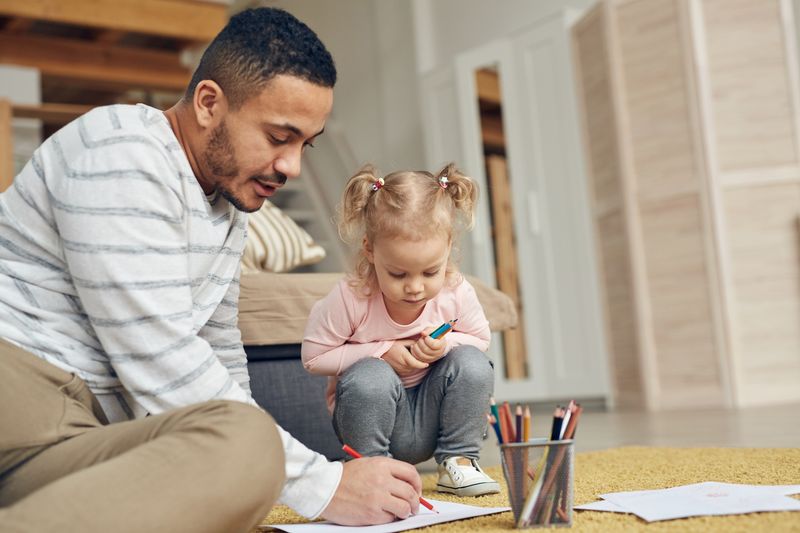 man drawing with young girl
