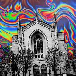 Marsh Chapel, Boston, in black and white and skewed towards the left, with a psychedelic rainbow sky behind it