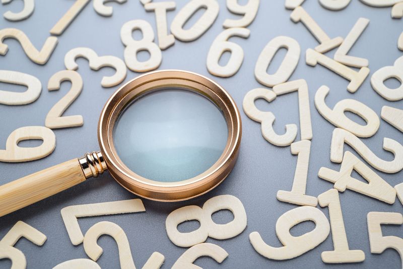 A magnifying glass and random wooden numbers