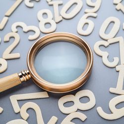 A magnifying glass and random wooden numbers