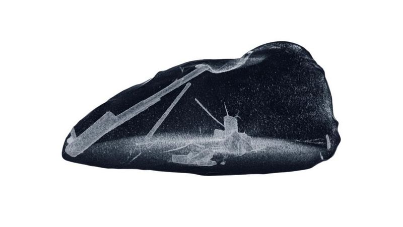 a view of the liquid nugget of metal and inside thin gray crystals forming.