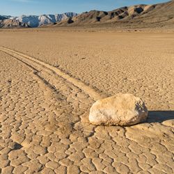 Vast playa, with a rock that has left a trail in the dried mud