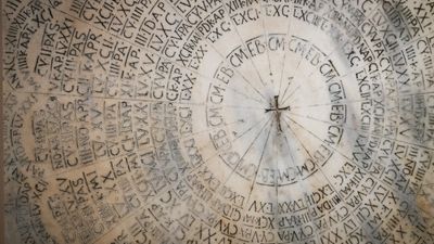 Ancient marble paschal calendar with circular Latin inscriptions and a central cross in the Cathedral of Ravenna