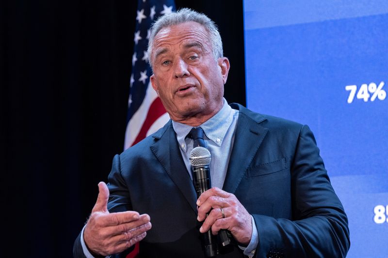 Robert F Kennedy Jr pictured speaking on stage with a microphone in his hand.