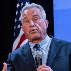 Robert F Kennedy Jr pictured speaking on stage with a microphone in his hand.
