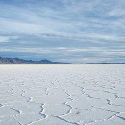 Salt flats stretch into the distance, white with ridges that give it texture despite being so flat 