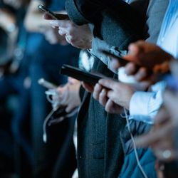 Row of people standing on their smartphone, technology 