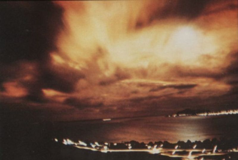 A burst of light caused by Starfish Prime explodes through the cloud cover, as seen from Honolulu, 1,450 kilometers (900 miles) away from the blast.