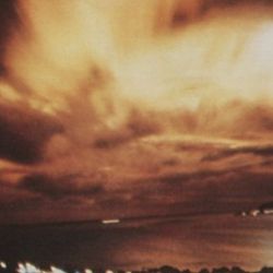 A burst of light caused by Starfish Prime explodes through the cloud cover, as seen from Honolulu, 1,450 kilometers (900 miles) away from the blast.