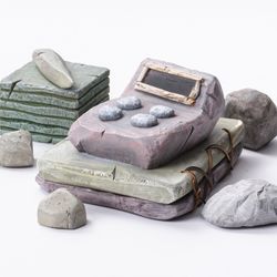 A computer rendering of a stone calculator and other desk items made from stone.