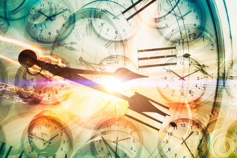 lots of clocks with one larger set of clock hands superimposed over the top and bright light in the middle