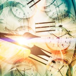 lots of clocks with one larger set of clock hands superimposed over the top and bright light in the middle