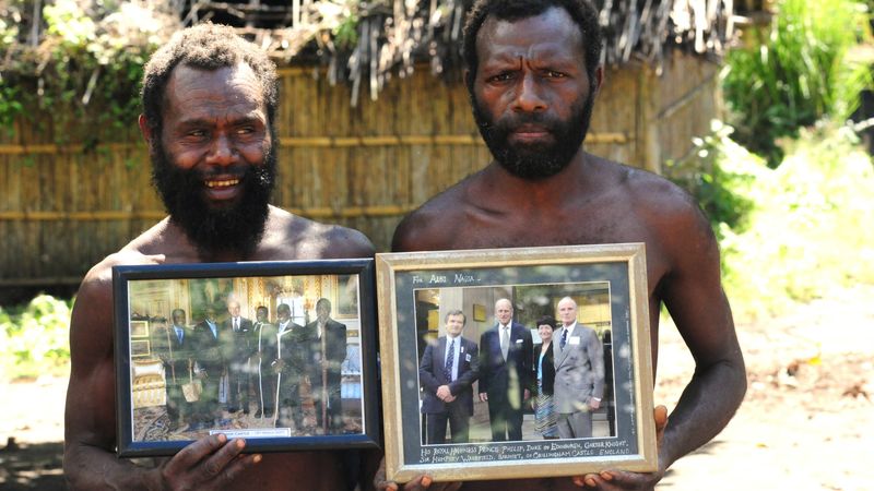 Two Yaohnanen tribesmen show framed pictures of their 2007 visit with Prince Philip, Duke of Edinburgh.
