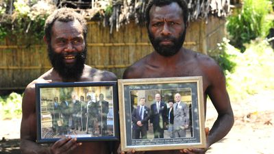 Two Yaohnanen tribesmen show framed pictures of their 2007 visit with Prince Philip, Duke of Edinburgh.