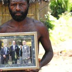 Two Yaohnanen tribesmen show framed pictures of their 2007 visit with Prince Philip, Duke of Edinburgh.