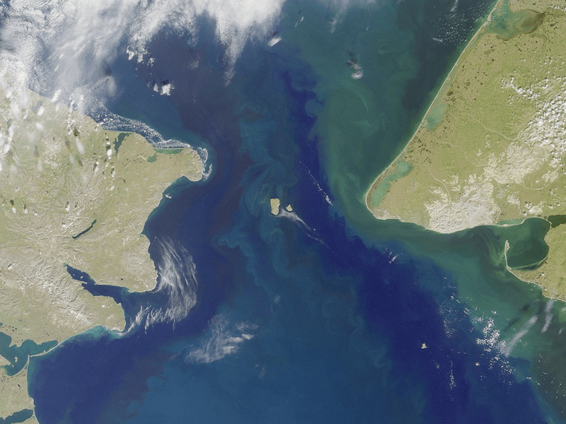 The Bering Strait from space. A hyperthetical dam would use the Diomede Islands in the middle to shift angles without being weakened