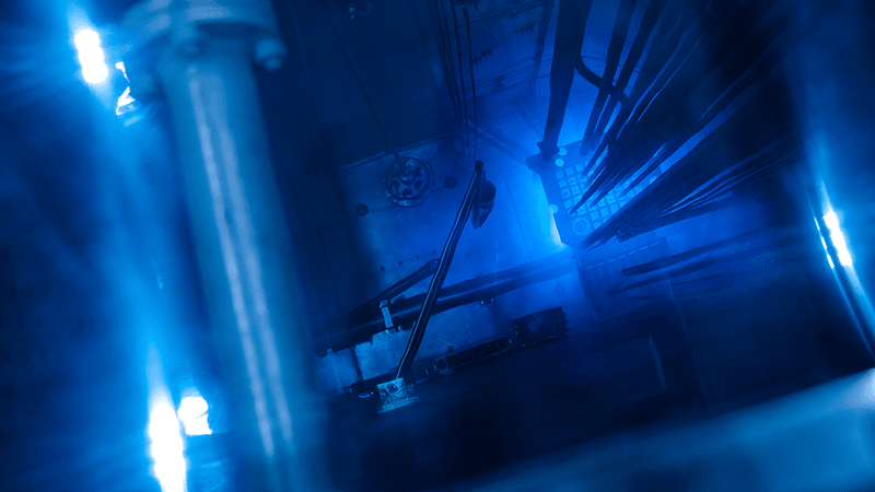 Blue glowing water caused by Cherenkov radiation in a nuclear reactor core.