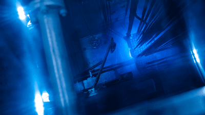 Blue glowing water caused by Cherenkov radiation in a nuclear reactor core.