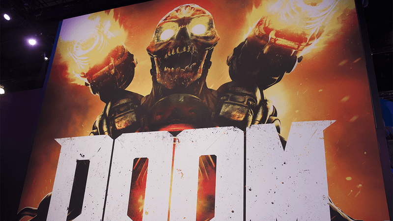 A poster for the game DOOM featuring a demon with two weapons on its shoulders.
