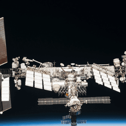 A photo of the ISS and beyond the limb of the Earth.