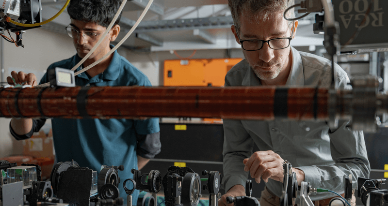 Yogesh Sridhar and Dr Sean Hodgman (right) making adjustments on the way to demonstrating the entanglement of atoms' momentum for the first time
