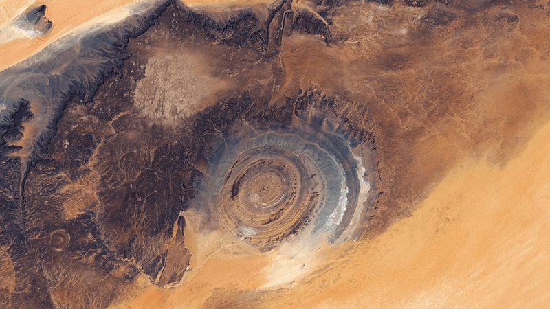 The Richat structure, viewed from above. A circular feature peaks out through the Sahara desert.