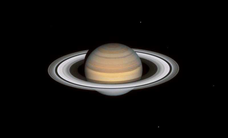 staurn is seen with its rings widely visible and shinging in white