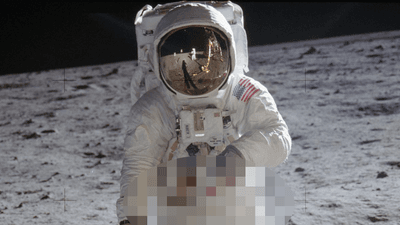 Buzz Aldrin in astronaut suit on the Moon. Neil Armstrong can be seen in the reflection on his visor.